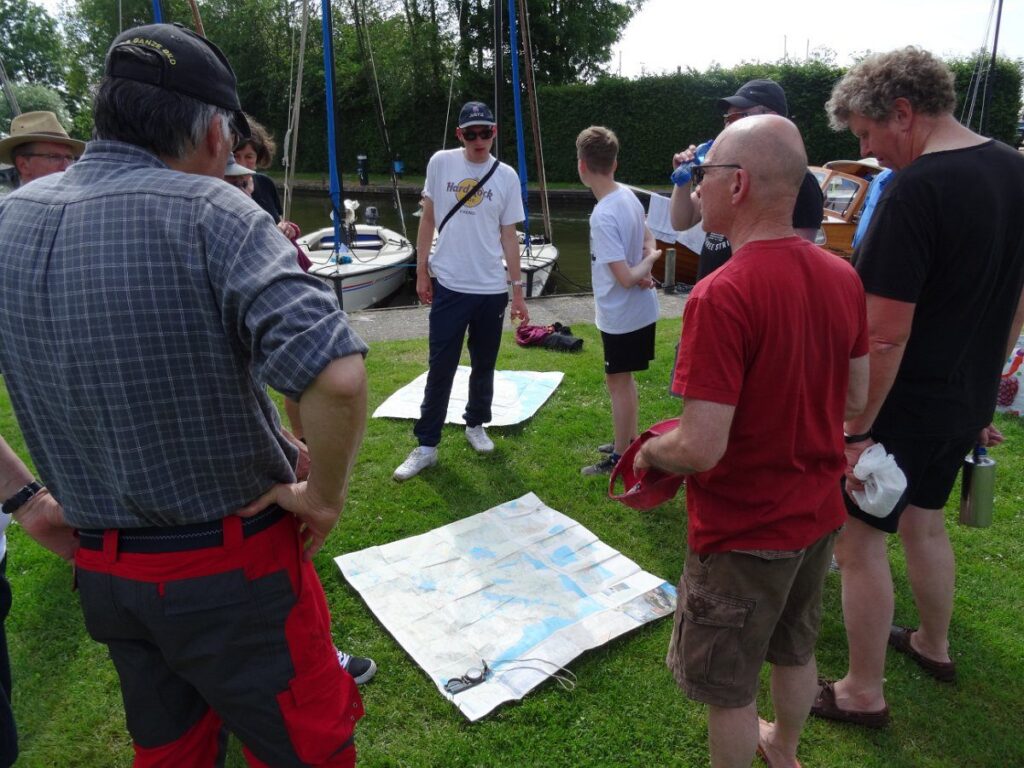Von wo weht der Wind. Crewbesprechung über Kurs und Ziele am Morgen