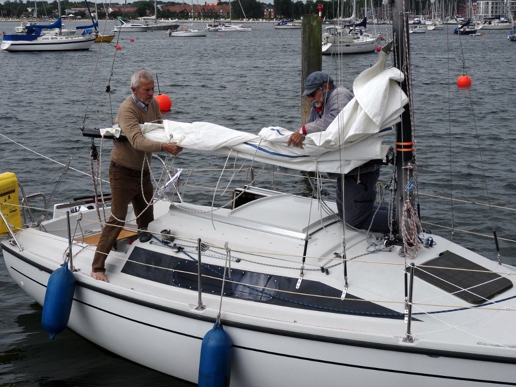 Starkwind ist verausgesagt. Die Crew bindet das erste Reff schon am Steg ein.