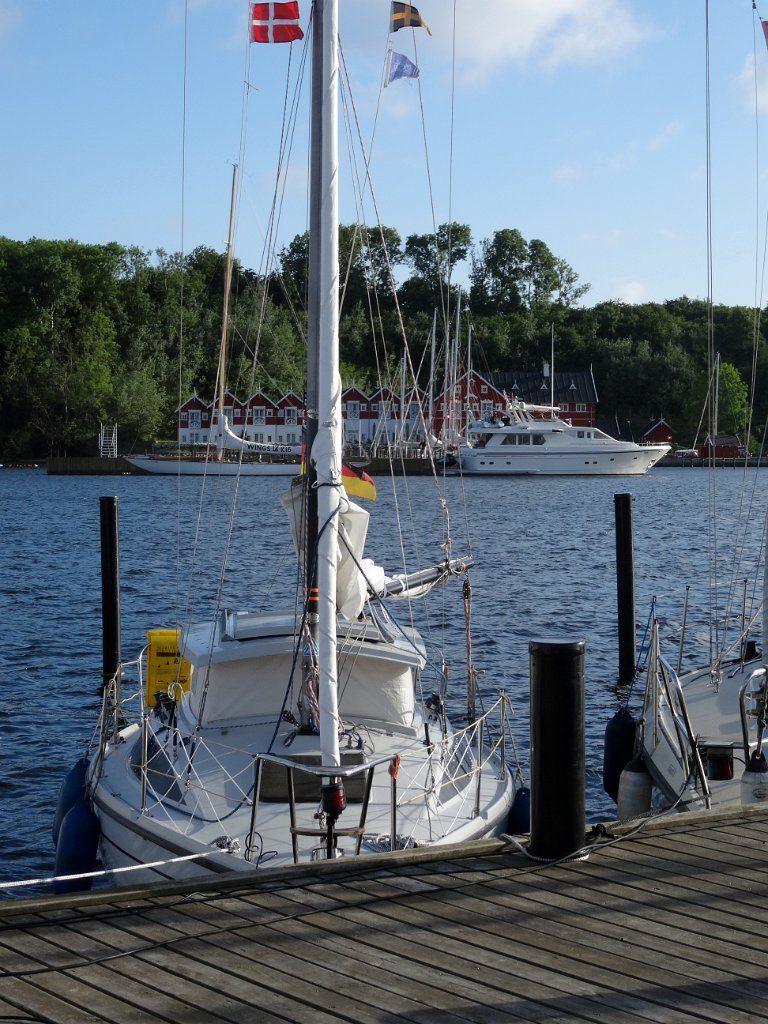 Molly mit dänischer Gastlandflagge am Steg der "Badelaug" in der Bucht von Dyvig. Bei dem Clubhotel auf der anderen Bucxhtseite kann man als Gastlieger festmachen. Kosten unbekannt. Die Bucht von Dyvig auf Als wird als eine der schönsten Buchten Dänemarks beschrieben. Hier kann man auch frei ankern.