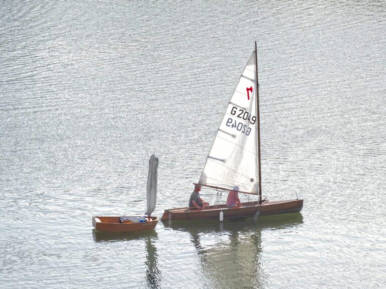 Frühes Saisonende Anfang September. Pirat mit Opti im Schlepp segelt Kurs Slippstelle vor Rehbach