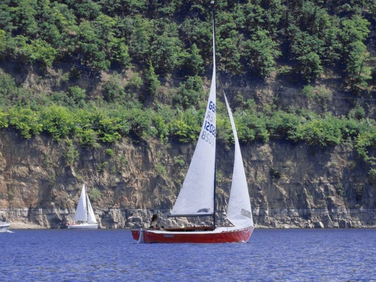 Segelsommer am Edersee. Die elegante Ostwind vor der Felswand bei Rehbach. Lightning aus Vollholz, oft Selbstbauten, werden in ihrer Heimat Amerika "Woodies" genannt